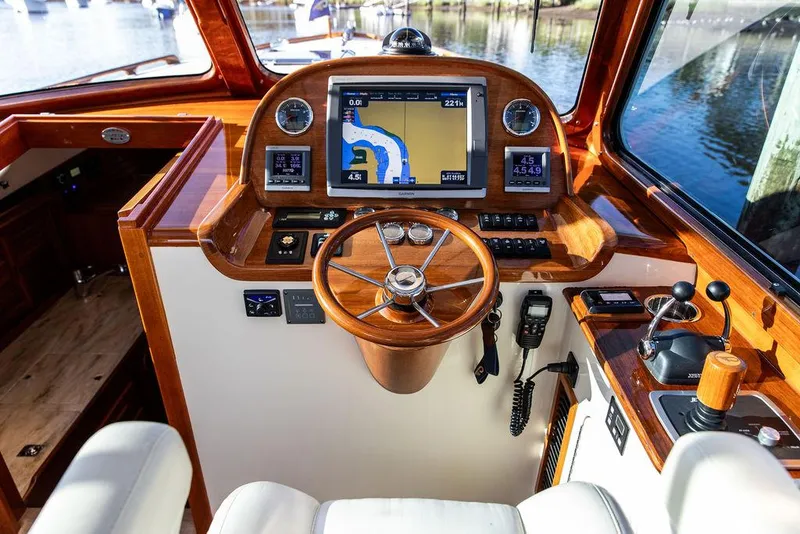 Slide: The Image of Hinckley Picnic Boat Mark III 2011 helm with navigation system and wooden steering wheel. - 47