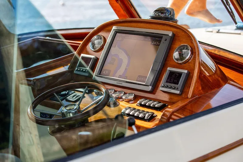 Slide: The Image of Hinckley Picnic Boat Mark III 2011 dashboard with navigation system and wooden finish. - 49