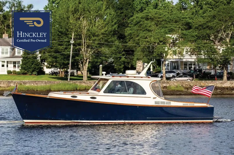 The Image of 2011 Hinckley Picnic Boat Mark III cruising on a river, certified pre-owned, with American flag. - 0
