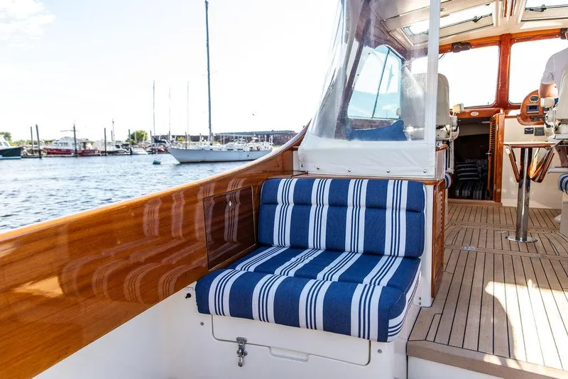 Slide: The Image of 2011 Hinckley Picnic Boat Mark III with striped seating, docked in a marina. - 39
