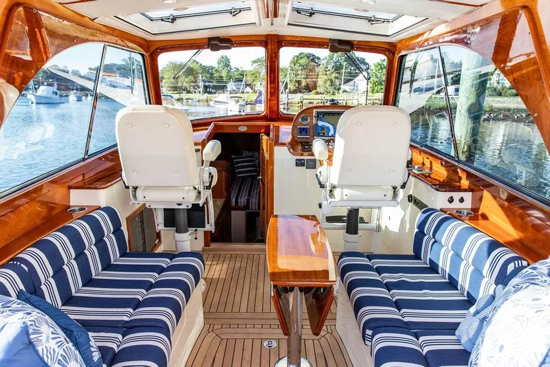 Slide: The Image of Interior of 2011 Hinckley Picnic Boat Mark III with striped seating and wooden finishes. - 42