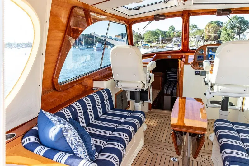 Slide: The Image of Luxurious 2011 Hinckley Picnic Boat Mark III interior with striped seating and wooden finishes. - 43