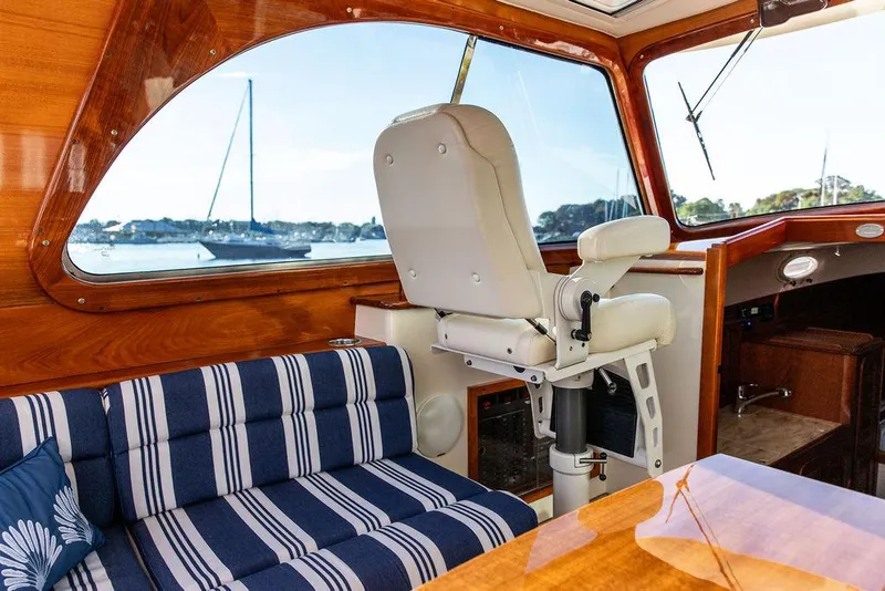 Slide: The Image of Interior of 2011 Hinckley Picnic Boat Mark III with striped seating and captain's chair. - 45