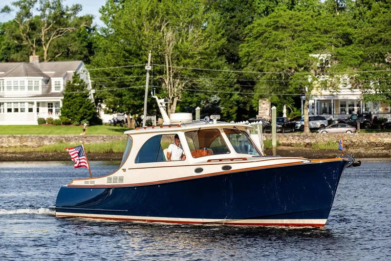 Slide: The Image of 2011 Hinckley Picnic Boat Mark III cruising on a scenic river with lush greenery. - 8