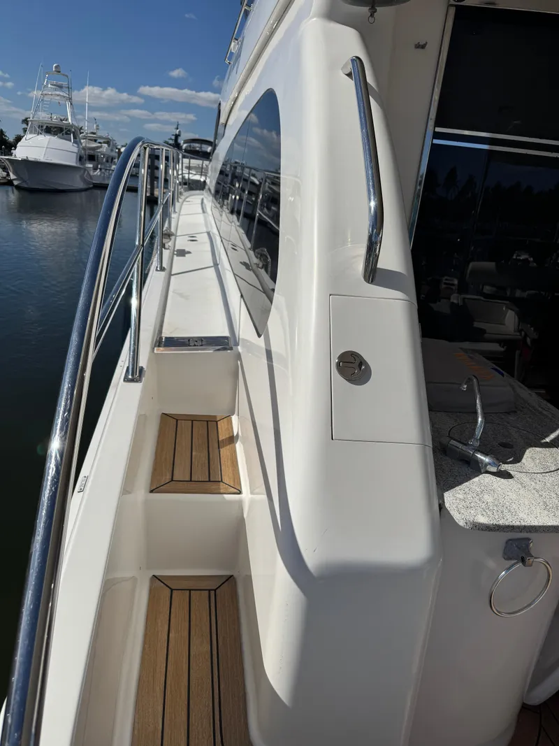 Slide: The Image of Side view of 2012 Neptunus 62 Flybridge yacht with sleek design and wooden steps. - 10