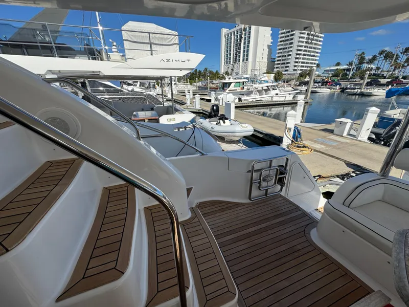 Slide: The Image of Luxurious 2012 Neptunus 62 Flybridge yacht docked at a marina with wooden deck. - 12