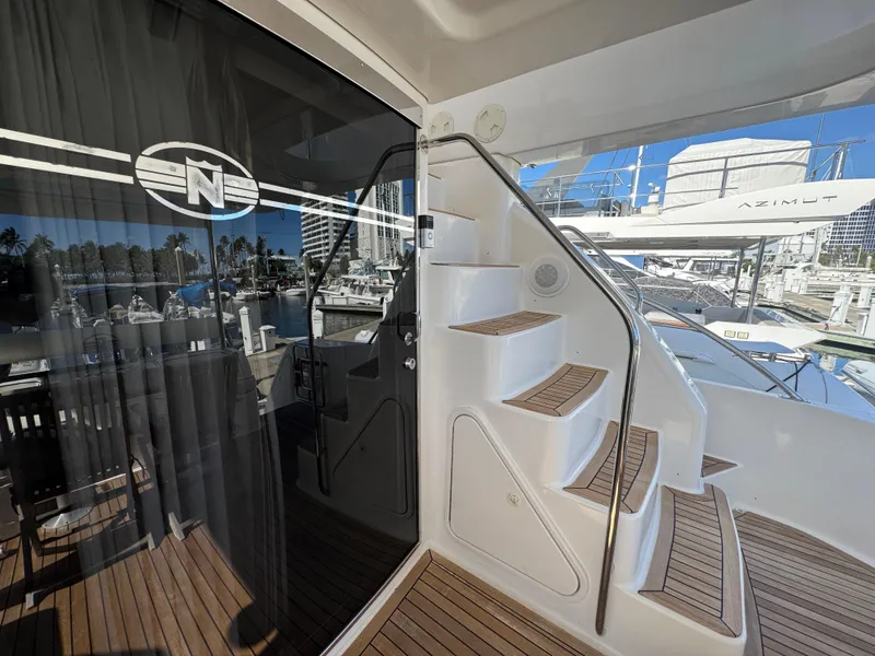 Slide: The Image of 2012 Neptunus 62 Flybridge yacht with elegant wooden stairs and marina view. - 13