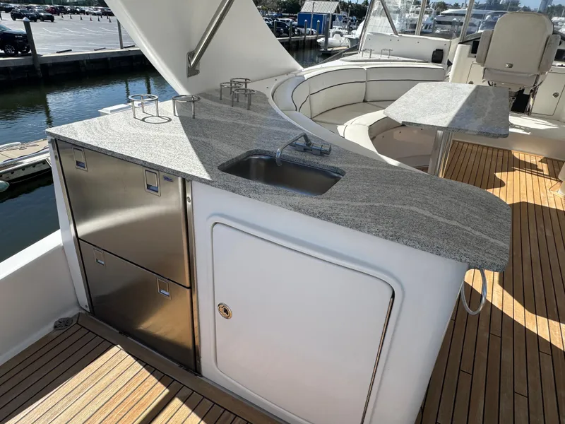 Slide: The Image of Luxurious 2012 Neptunus 62 Flybridge yacht with sleek outdoor kitchen and seating area. - 19