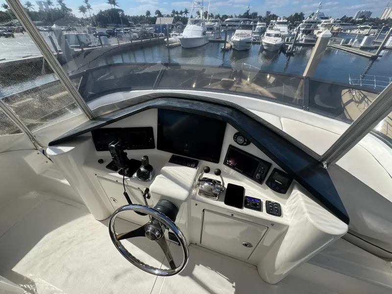 Slide: The Image of Flybridge helm of 2012 Neptunus 62 yacht, overlooking marina with multiple boats. - 29