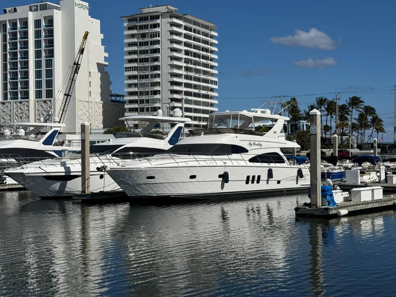 Slide: The Image of 2012 Neptunus 62 Flybridge yacht docked in a marina with buildings in the background. - 3