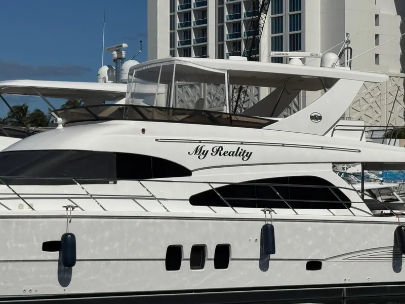 Slide: The Image of 2012 Neptunus 62 Flybridge yacht named "My Reality" docked near a modern building. - 4