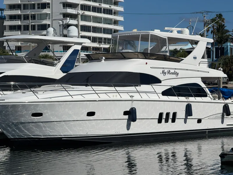 Slide: The Image of 2012 Neptunus 62 Flybridge yacht docked in marina, sleek design, white exterior. - 5