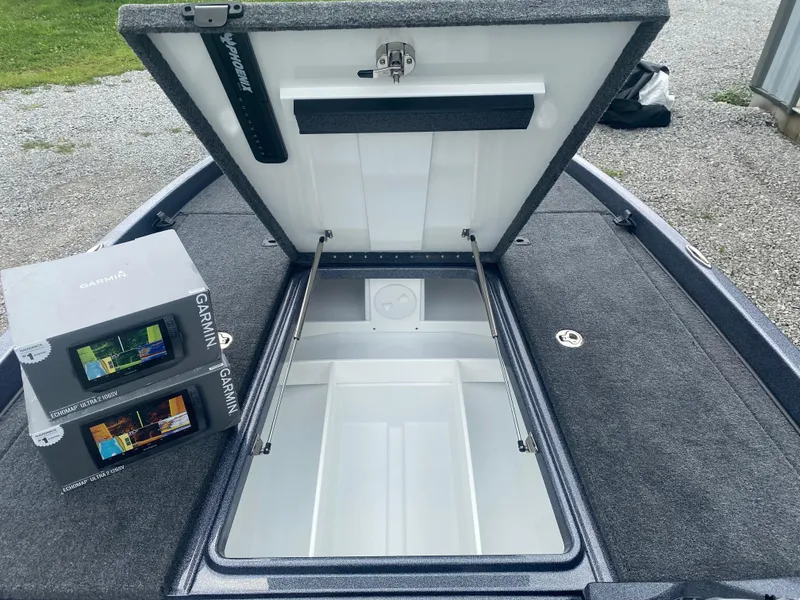 Slide: The Image of 2026 Phoenix 721 ZXL boat storage compartment with Garmin electronics boxes on deck. - 13