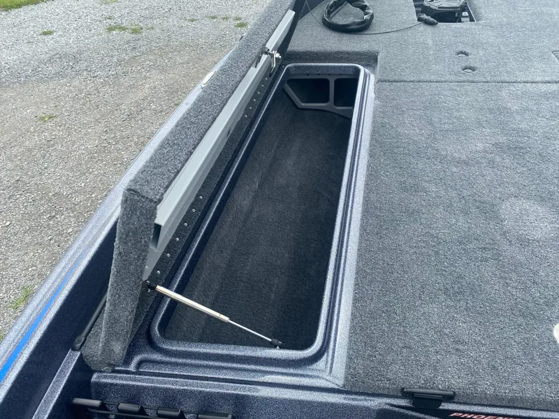 Slide: The Image of Open storage compartment in 2026 Phoenix 721 ZXL boat, featuring carpeted interior. - 14