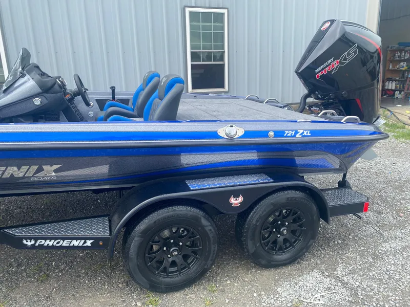 Slide: The Image of 2026 Phoenix 721 ZXL boat with Mercury Pro XS engine, parked on gravel. - 6