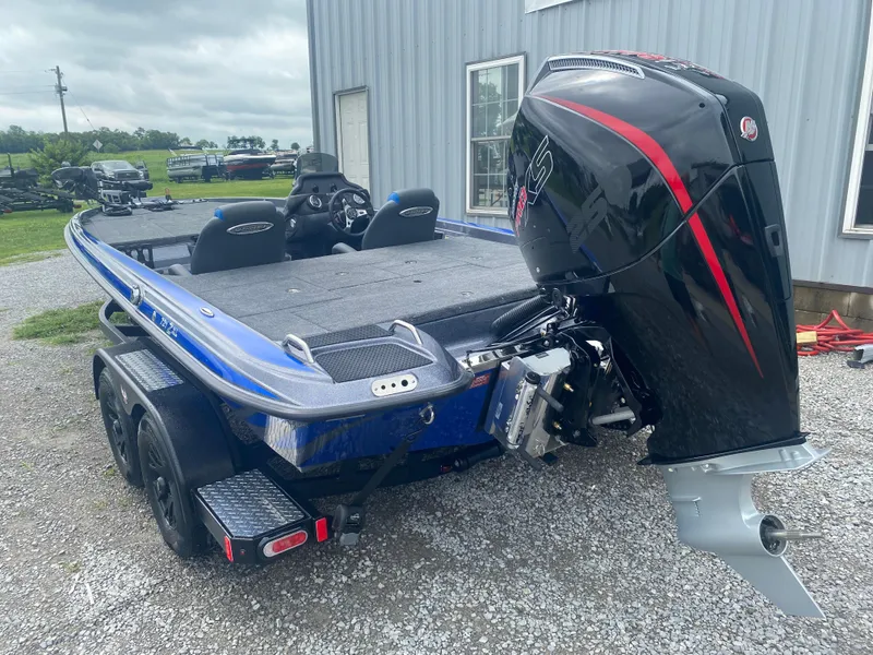 Slide: The Image of 2026 Phoenix 721 ZXL boat with powerful outboard motor, parked on gravel near a building. - 8