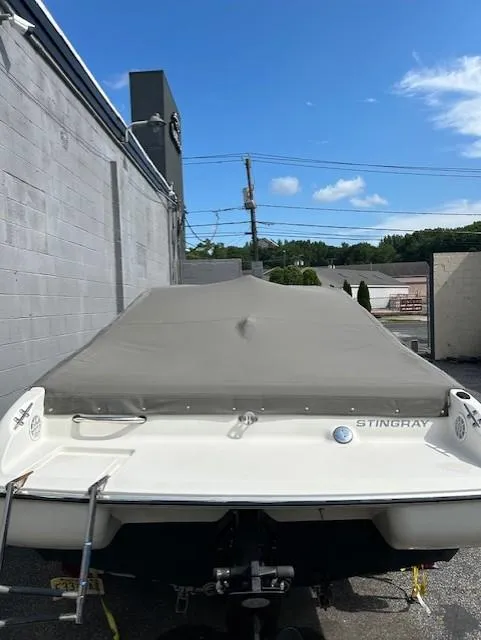 Slide: The Image of 2004 Stingray 190 CS/CX boat with cover, parked outdoors under blue sky. - 4