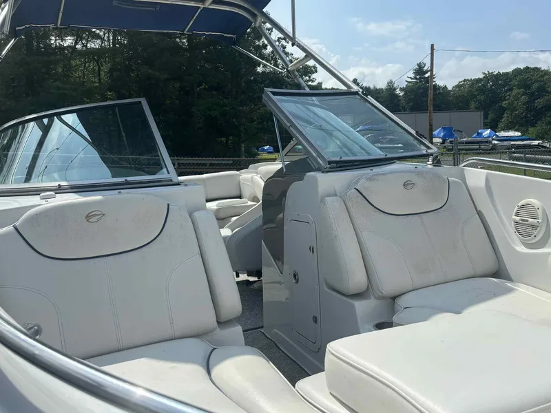 Slide: The Image of 2006 Crownline 230LS boat interior with white seating and blue canopy. - 5