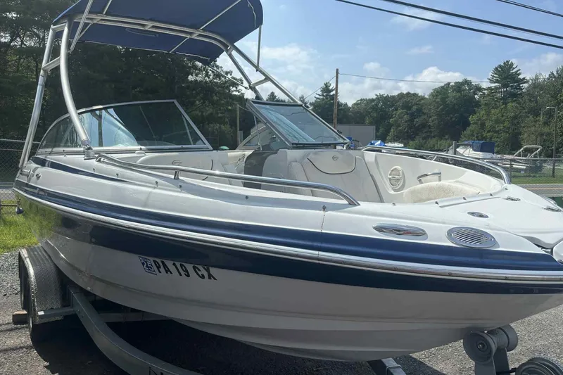 Slide: The Image of 2006 Crownline 230 LS boat on trailer, featuring sleek design and blue canopy. - 7