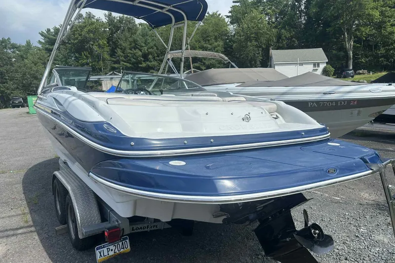 Slide: The Image of 2006 Crownline 230 LS boat on trailer, parked outdoors with trees in background. - 8