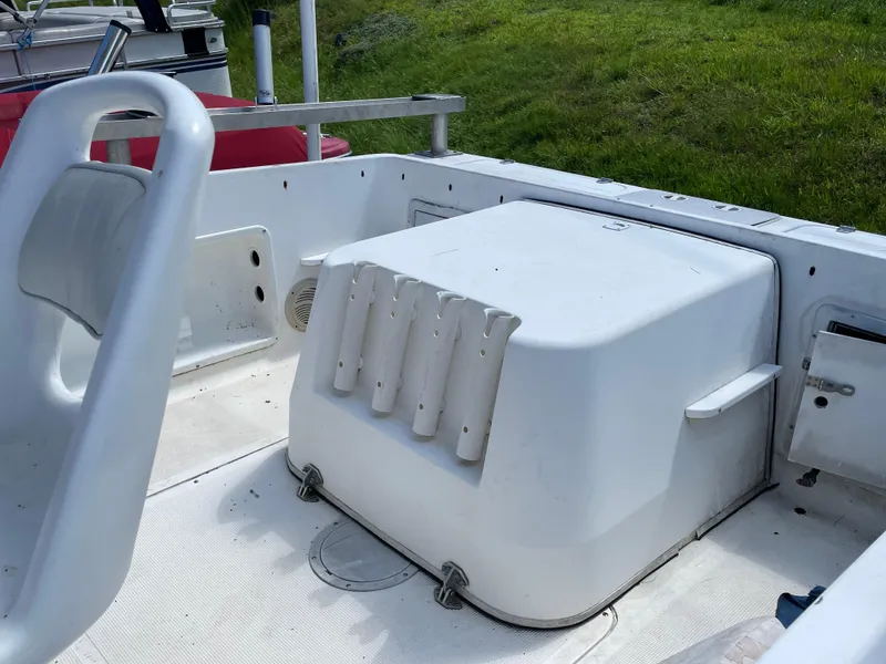 Slide: The Image of 1999 Sea Sport 2044 Walk Around boat interior with rod holders and seating. - 2