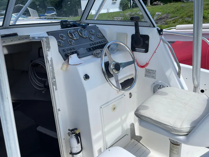 Slide: The Image of 1999 Sea Sport 2044 Walk Around boat cockpit with steering wheel and control panel. - 8