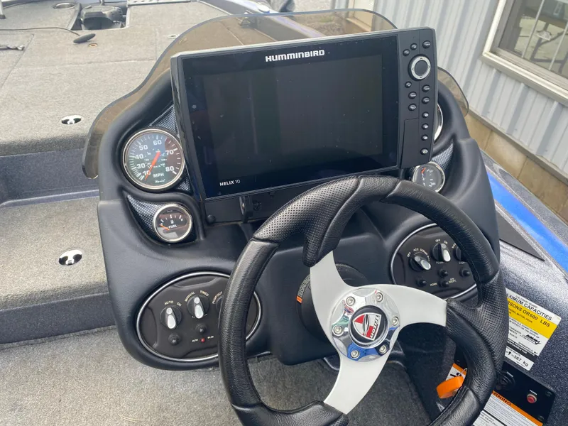 Slide: The Image of 2017 Triton 179 TrX boat dashboard with Humminbird Helix 10 display and steering wheel. - 12
