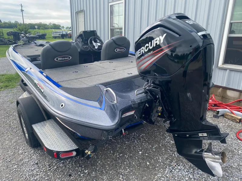 Slide: The Image of 2017 Triton 179 TrX boat with Mercury outboard motor, parked on gravel near a building. - 8