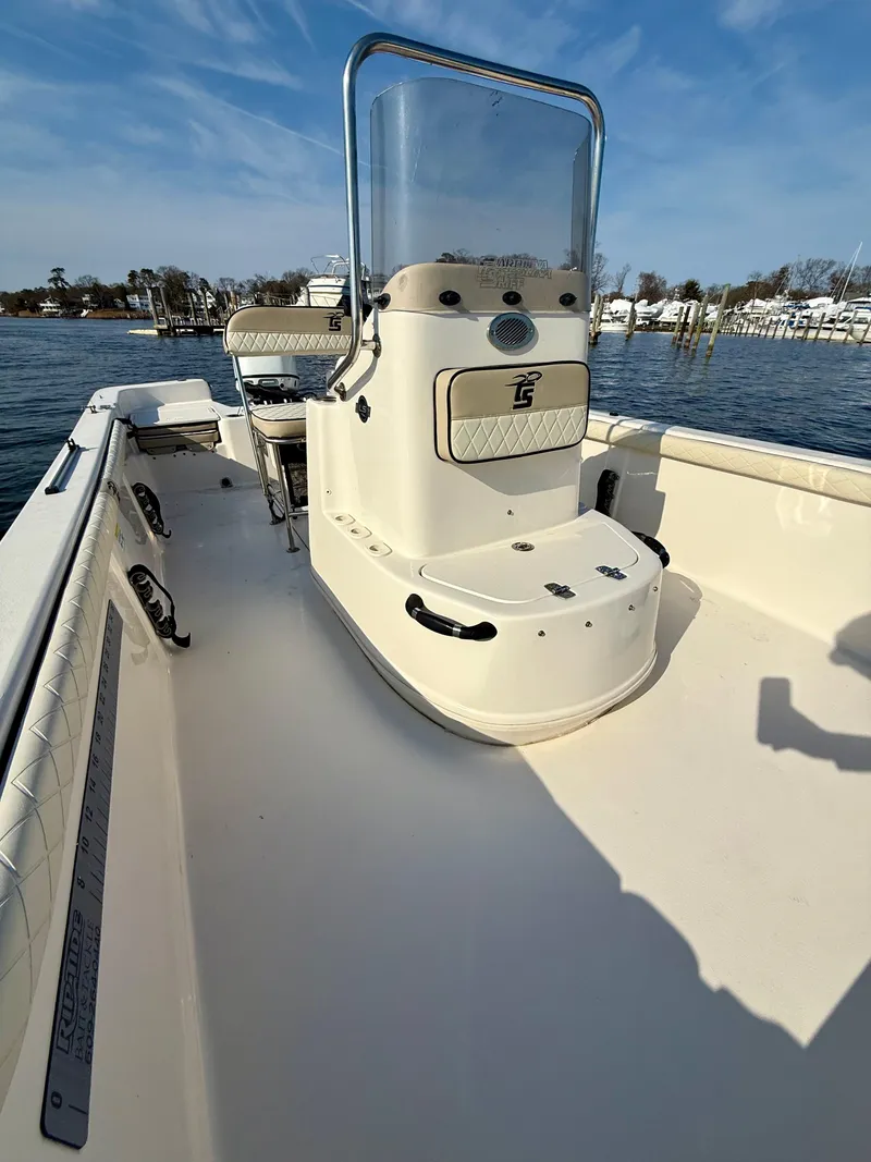Slide: The Image of 2023 Carolina Skiff 21 LS boat on water, featuring center console and spacious deck. - 10