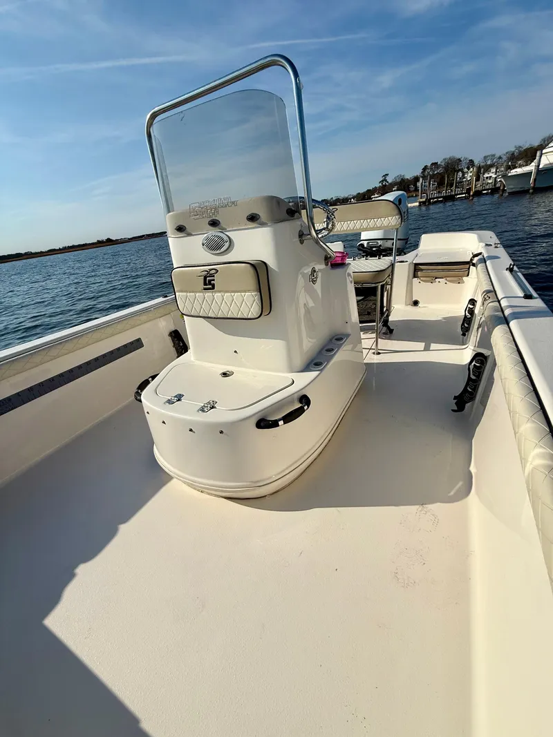 Slide: The Image of 2023 Carolina Skiff 21 LS boat on water, featuring center console and spacious deck. - 11