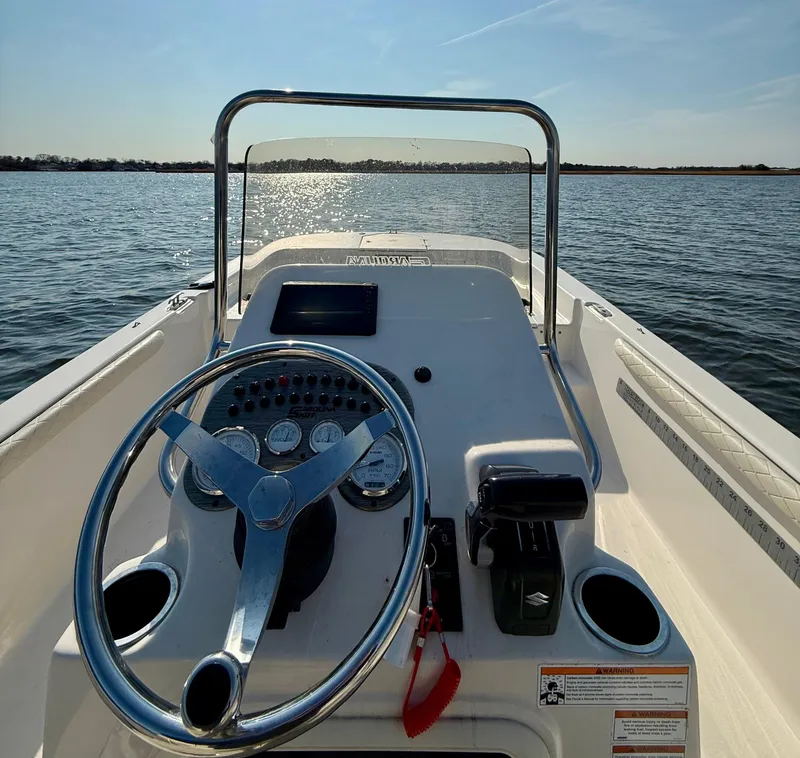 Slide: The Image of 2023 Carolina Skiff 21 LS boat dashboard with steering wheel on open water. - 15