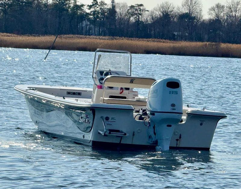 Slide: The Image of 2023 Carolina Skiff 21 LS boat on calm water, rear view with outboard motor. - 3