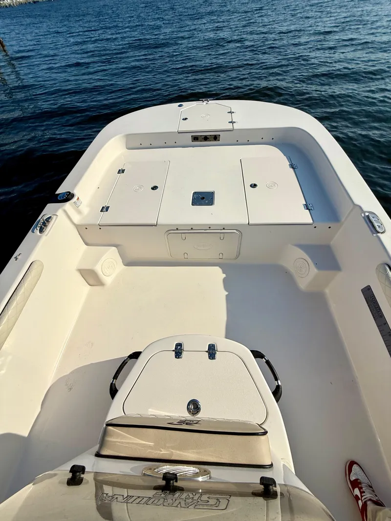 Slide: The Image of 2023 Carolina Skiff 21 LS boat interior, white deck, on calm water. - 4