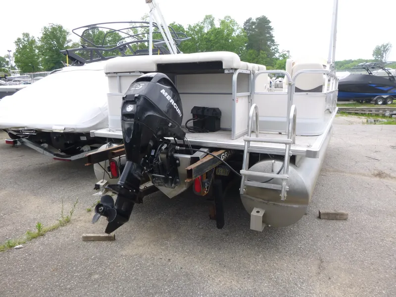 Slide: The Image of 2007 Smoker Craft M-8520 Cruise RE pontoon boat with Mercury outboard motor, parked outdoors. - 4