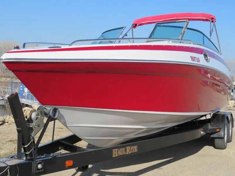 Slide: The Image of 2012 Crownline 275 SS boat with red and white exterior on a trailer. - 0