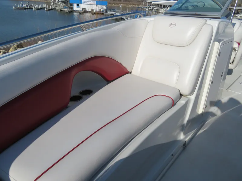 Slide: The Image of 2012 Crownline 275 SS boat interior with white and red seating, dockside view. - 21