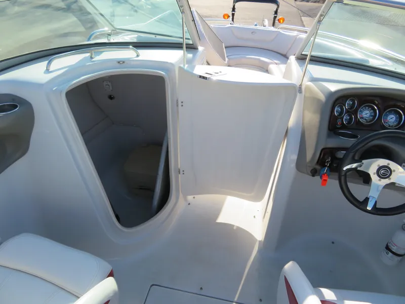 Slide: The Image of 2012 Crownline 275 SS boat interior with open cabin door and steering console. - 24