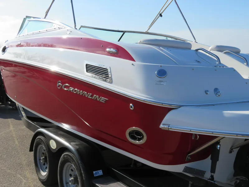 Slide: The Image of 2012 Crownline 275 SS boat with red and white exterior on a trailer. - 3
