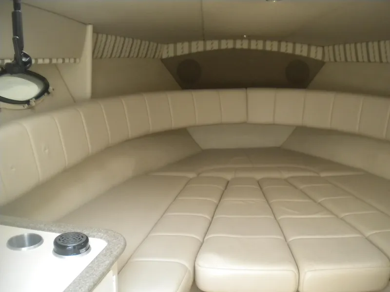 Slide: The Image of 2002 Formula 330 SS boat interior with beige cushioned seating and compact kitchenette. - 13