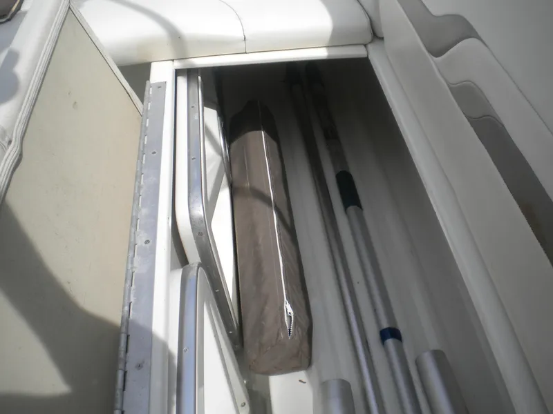 Slide: The Image of Storage compartment in a 2002 Formula 330 SS boat, containing poles and a covered item. - 20