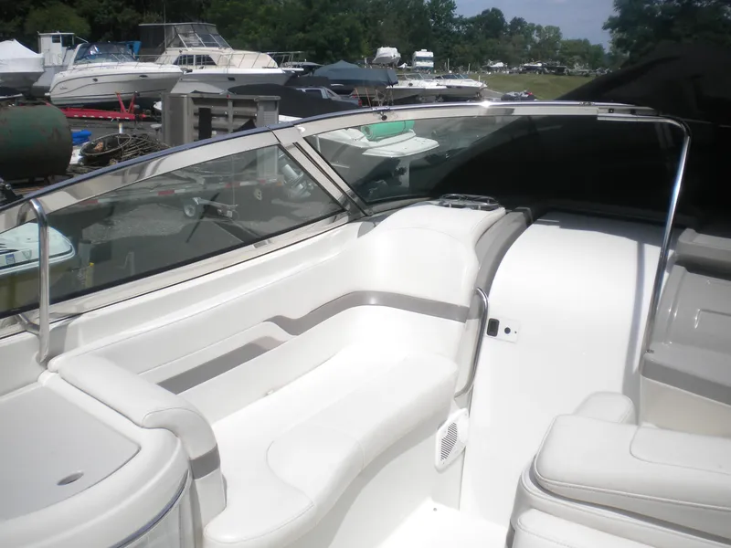 Slide: The Image of 2002 Formula 330 SS boat interior with white seating and windshield, docked among other boats. - 9