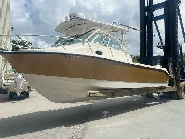 Slide: The Image of 2008 Edgewater 265 Express boat lifted by forklift, displayed outdoors. - 0