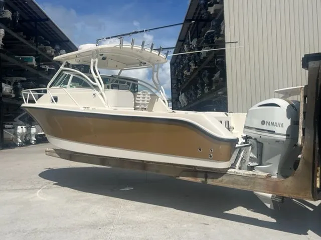 Slide: The Image of 2008 Edgewater 265 Express boat with Yamaha engine on forklift, outdoor storage facility. - 1