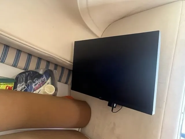 Slide: The Image of Flat-screen TV inside 2008 Edgewater 265 Express boat cabin with striped cushions. - 12