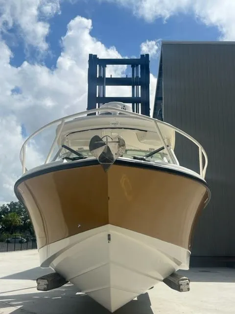 Slide: The Image of 2008 Edgewater 265 Express boat docked under a cloudy sky. - 2