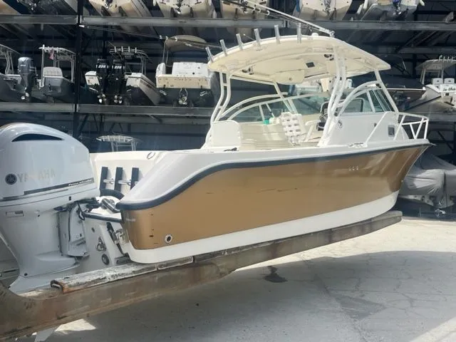 Slide: The Image of 2008 Edgewater 265 Express boat on dry dock, featuring a sleek design and powerful outboard engine. - 3