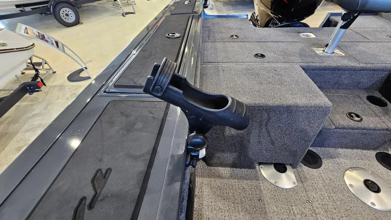 Slide: The Image of 2021 Tracker Targa V-18 Combo boat interior with rod holder and carpeted deck. - 19