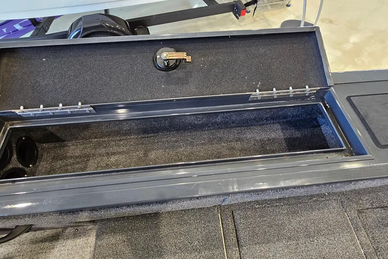 Slide: The Image of Open storage compartment in 2021 Tracker Targa V-18 Combo boat, featuring carpeted interior. - 24