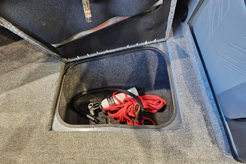 Slide: The Image of Storage compartment in 2021 Tracker Targa V-18 Combo boat with red rope and accessories. - 26