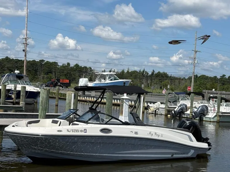 Slide: The Image of 2019 Bayliner VR6 boat docked at marina under blue sky with clouds. - 2